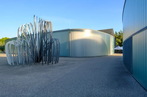 Moderne Architektur mit Metallskulptur und glatten Wänden. (KI generiert)