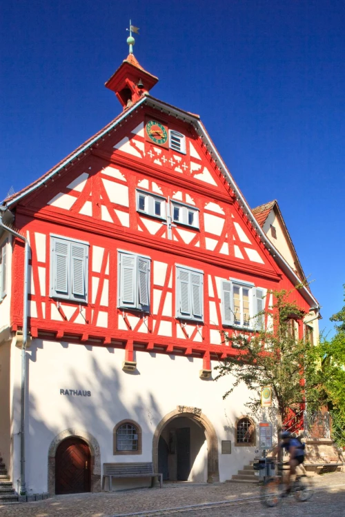 Historisches Rathaus mit Fachwerk und Uhrturm, blauem Himmel (KI generiert)