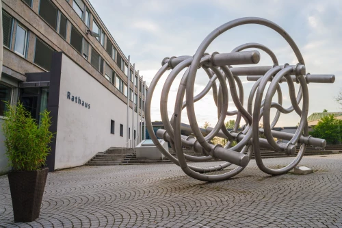 Moderne Skulptur aus Metall vor einem Rathausgebäude mit der Aufschrift Rathaus. (KI generiert)