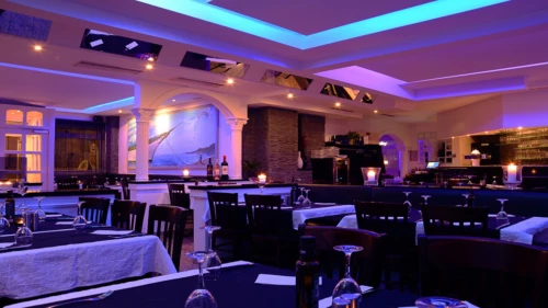 Ein stilvolles Restaurant mit blau beleuchteter Decke und eleganten Tischen. (KI generiert)