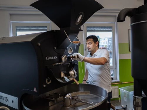 Mann bedient eine professionelle Kamera an einem Stativ in einem Studio. (KI generiert)