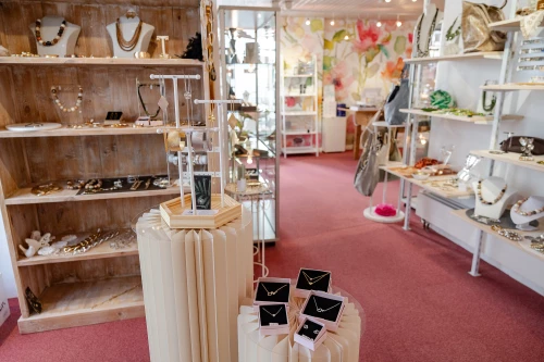 Ein Juweliergeschäft mit Schmuck auf Regalen und Ständern. (KI generiert)