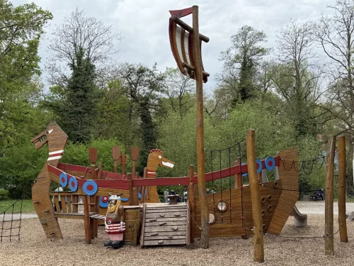 Holzspielplatz mit Wikingerschiff und Figur. (KI generiert)